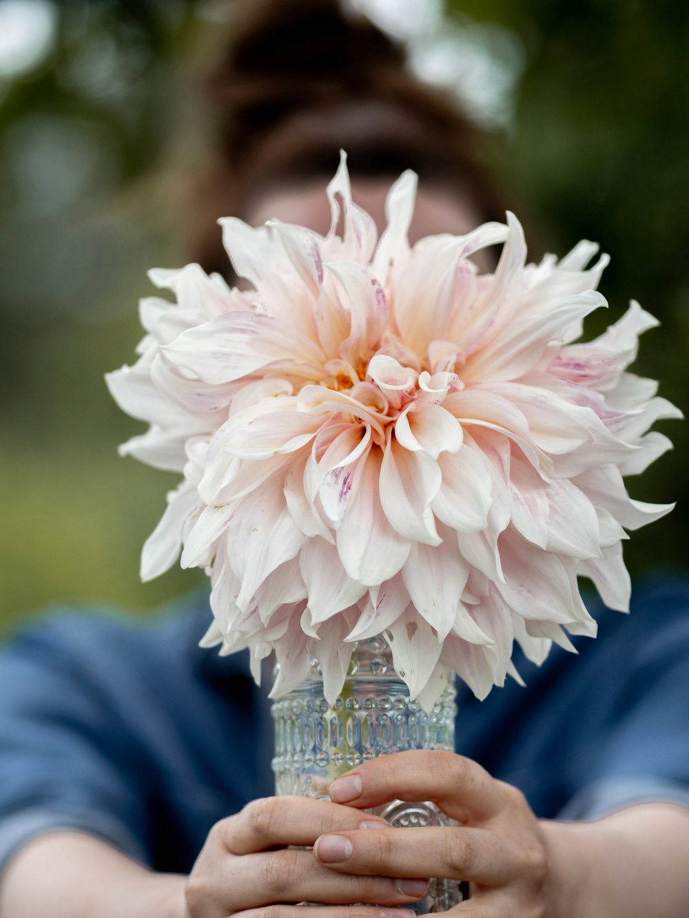 a person holding a vase with a flower in it