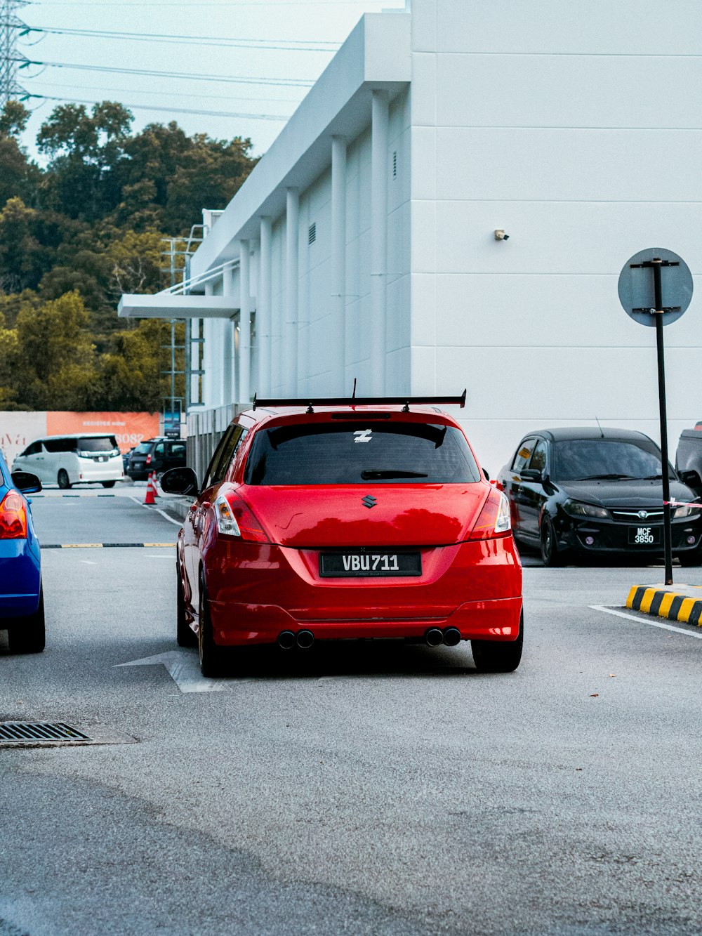 a red car parked in a parking lot next to a building