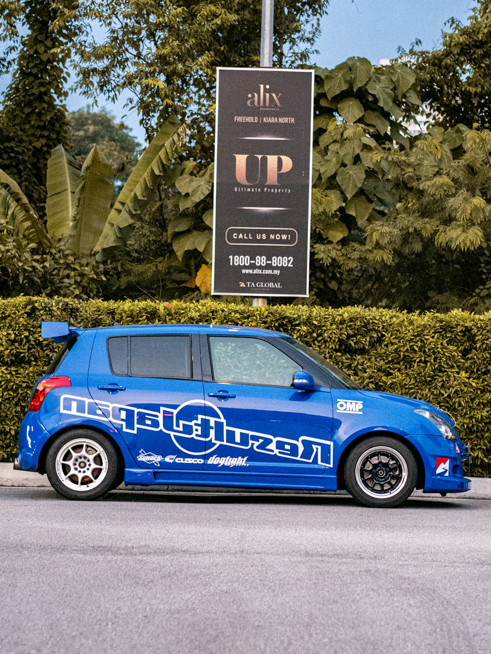 a small blue car parked on the side of the road