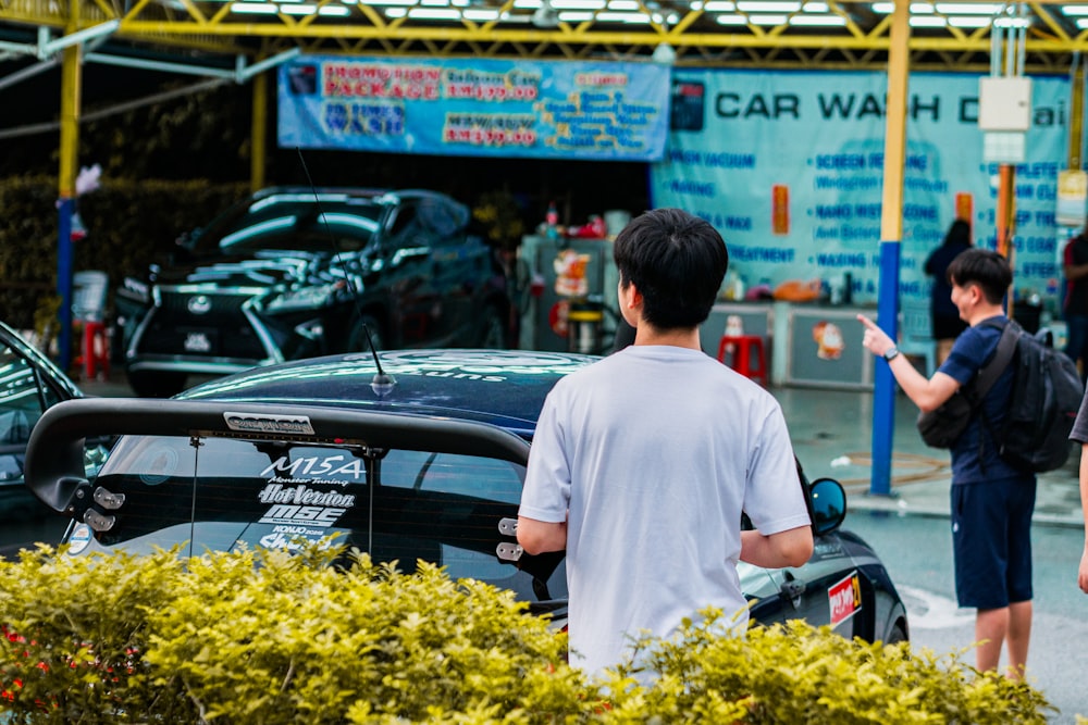 a group of people standing around a car wash