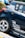 A close-up view of the rear section of a sporty car adorned with multiple brand decals including Apex, Recaro, and Power Filter. The car is navy blue with a silver stripe and features custom wheels.