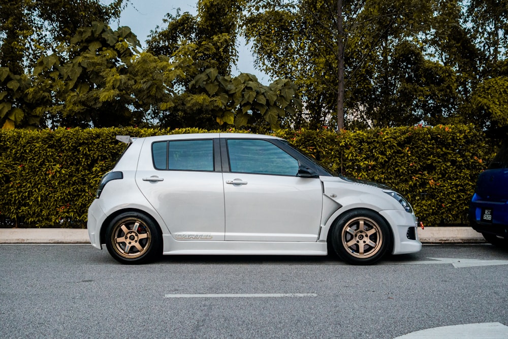 a small white car parked on the side of the road