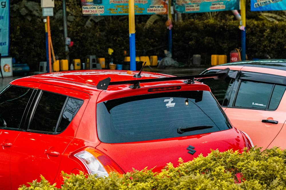 a couple of red cars parked next to each other