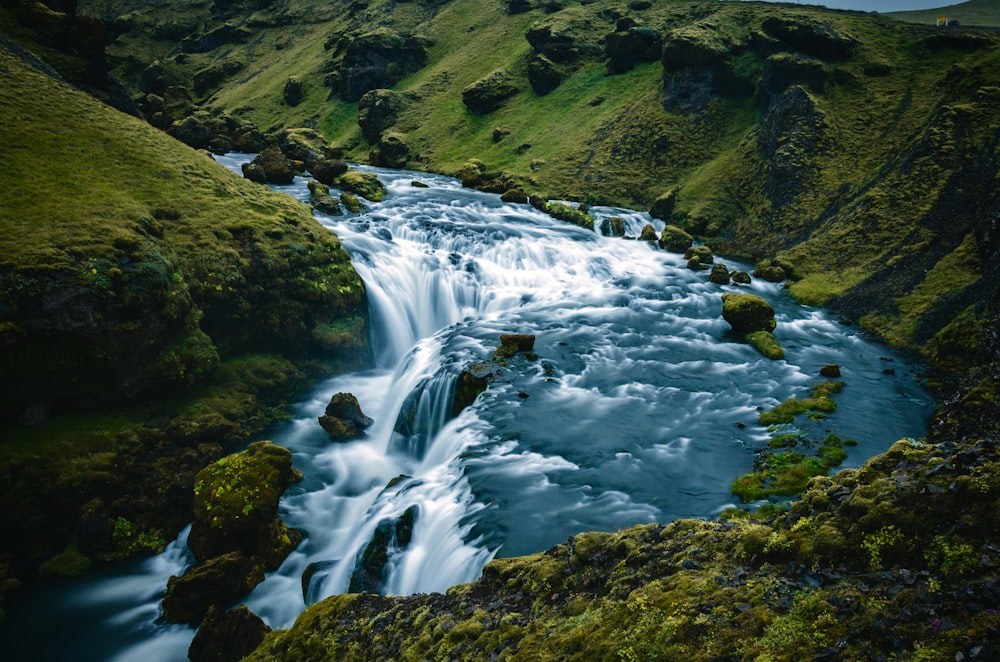 a river running through a lush green hillside