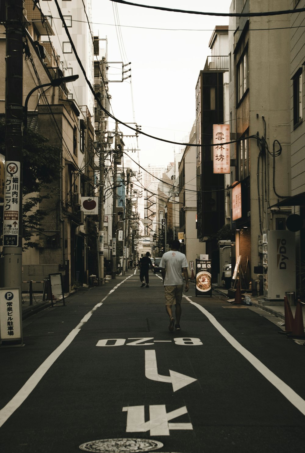 a man riding a skateboard down a street next to tall buildings