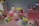 A collection of cute, colorful plush toys is displayed on a set of pink platforms. The toys have large, expressive eyes and resemble popular cartoon characters. Around the toys, there are small, colorful blocks, adding to the vibrant aesthetic.