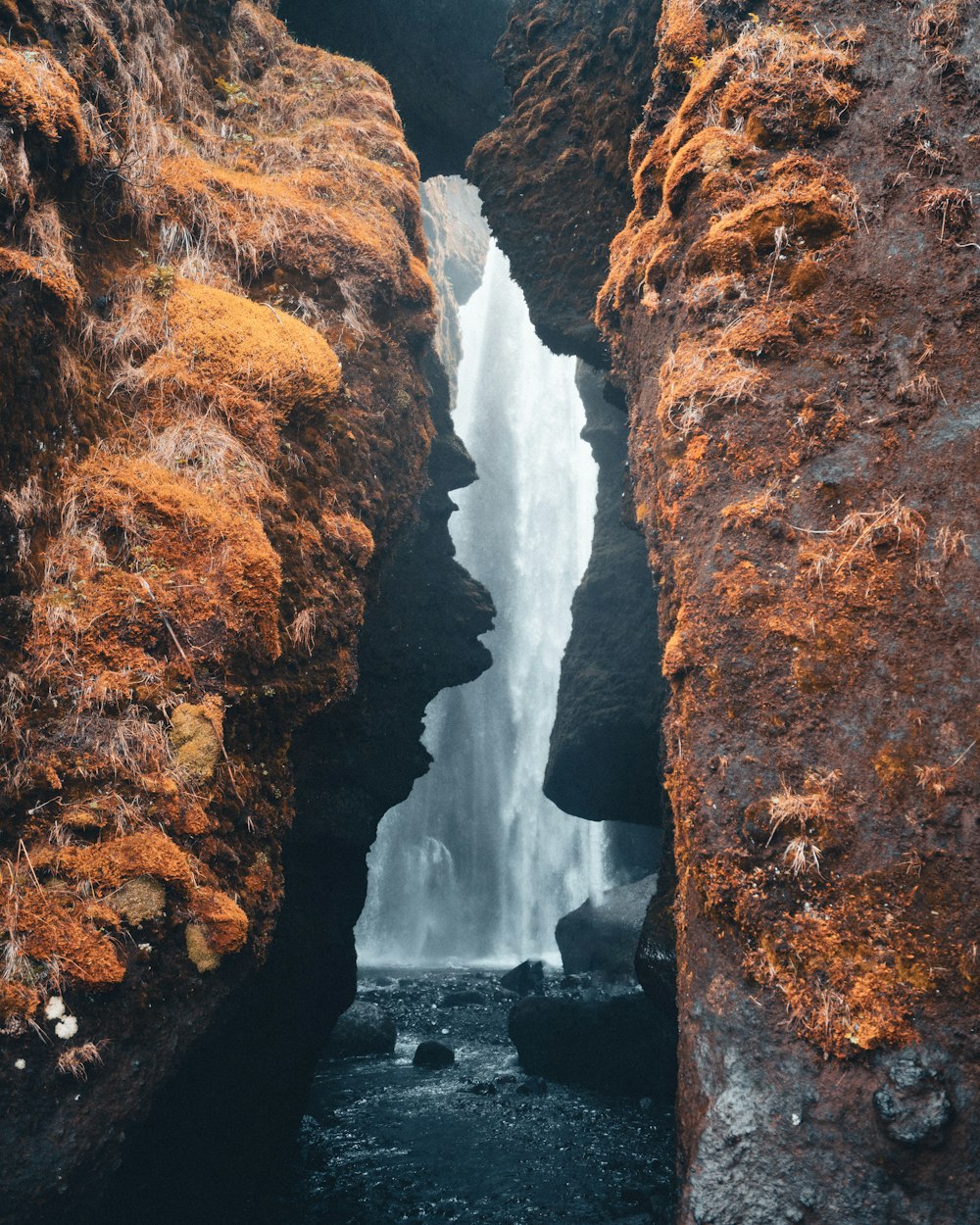 a small waterfall is coming out of the rocks