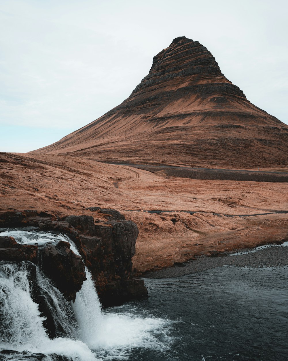 a mountain with a waterfall in front of it