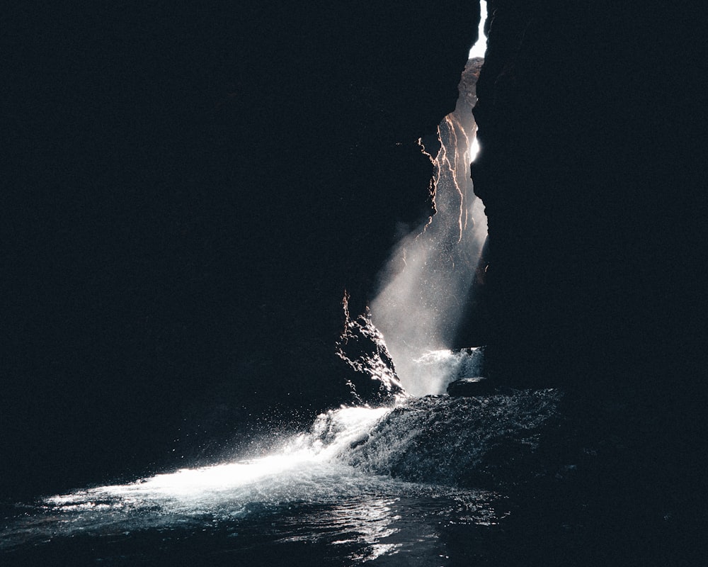 a large rock sticking out of a body of water