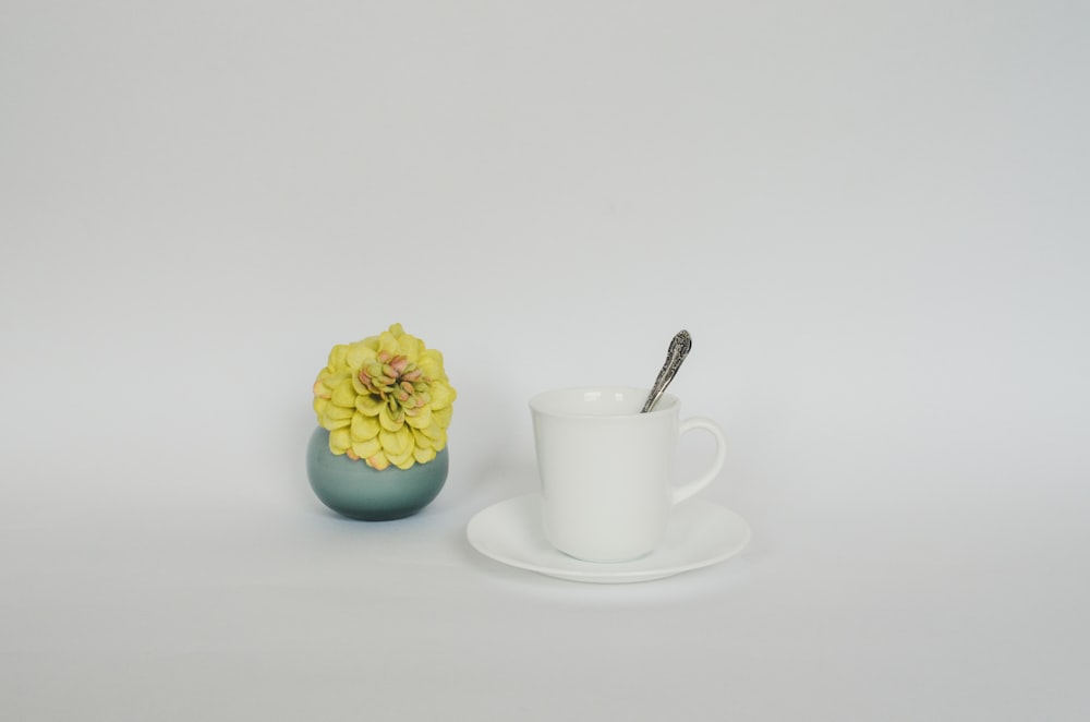 a cup and saucer with a flower in it