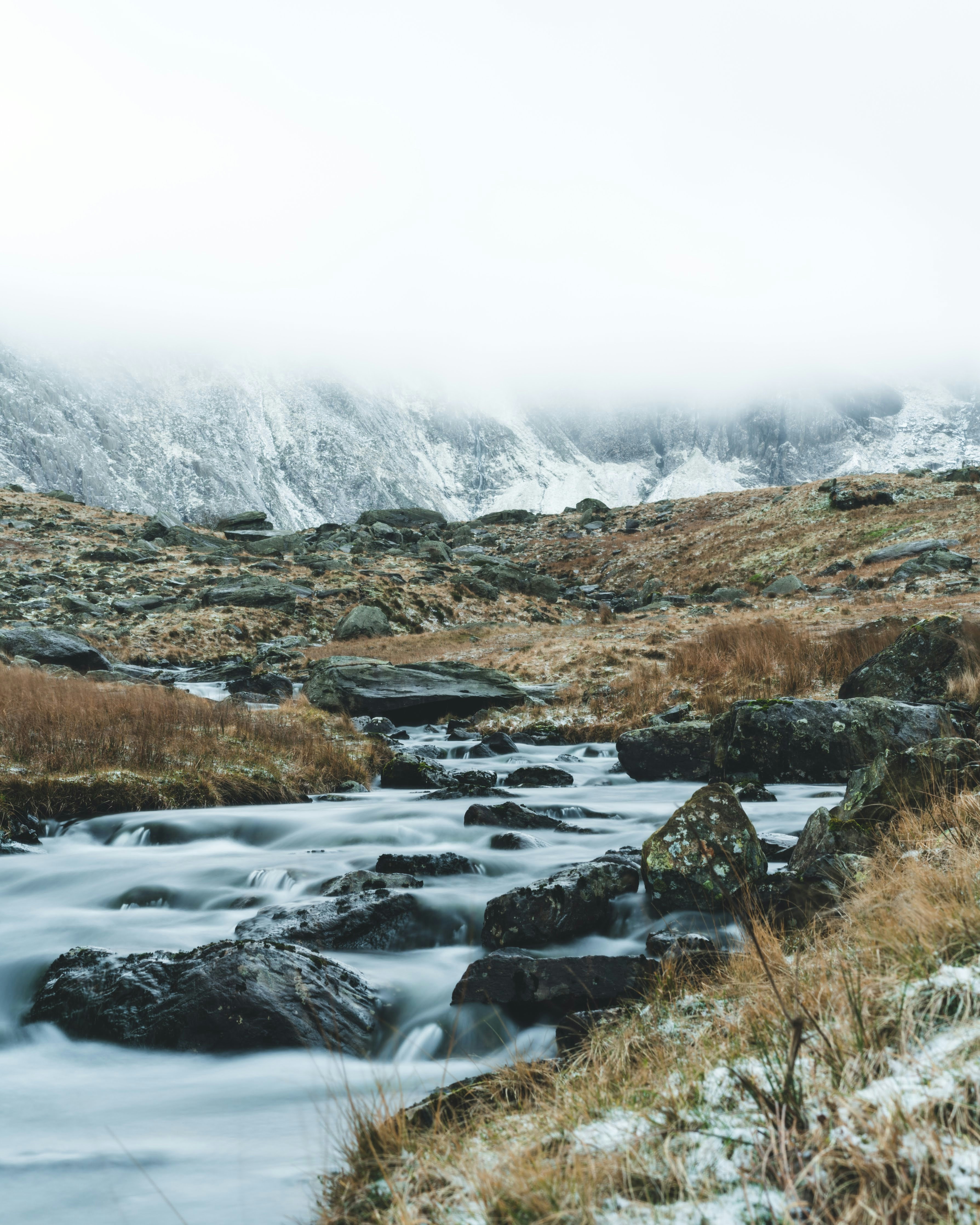 a stream running through a grass covered field
