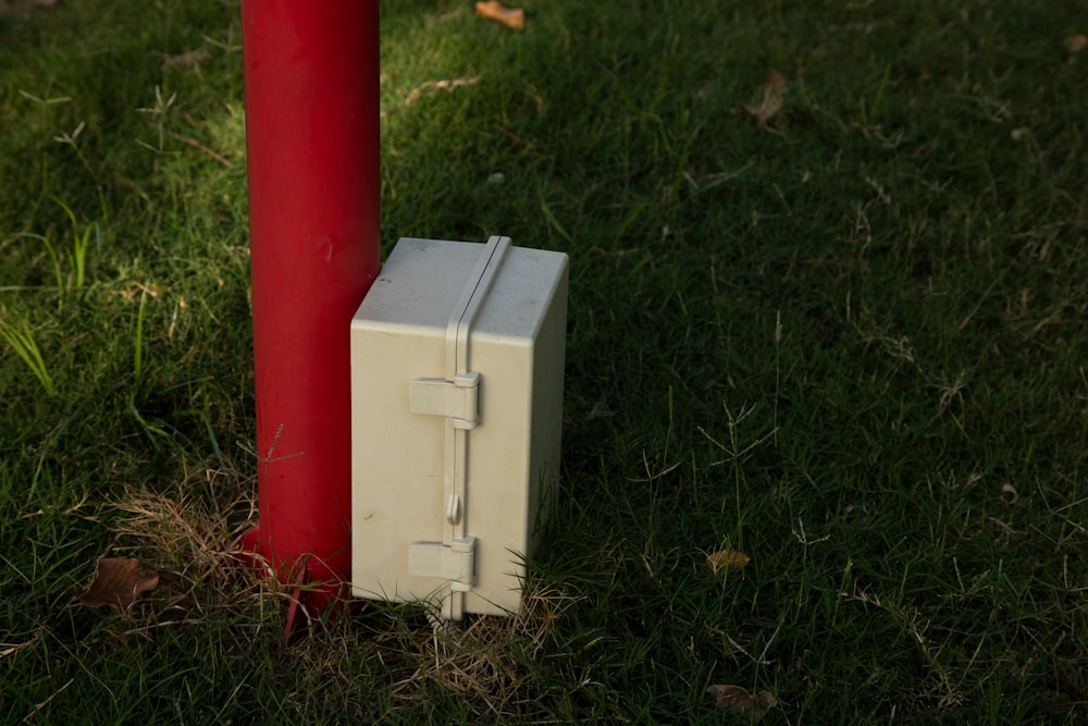 a small refrigerator sitting next to a red pole