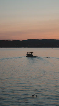 A serene figure in a boat glides across calm waters under a twilight sky, symbolizing transition and hope.
