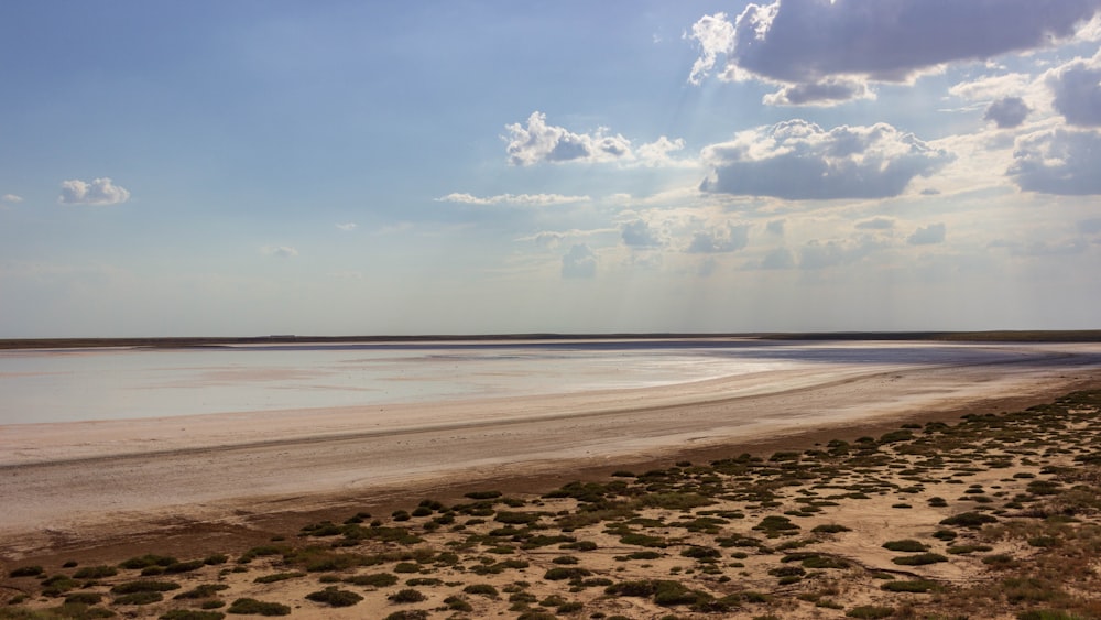 a sandy beach with a body of water in the distance