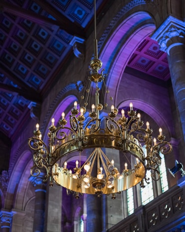 Close-up of a technician carefully installing a grand chandelier with royal blue accents.