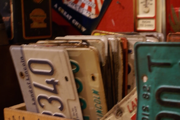 Rows of colorful license plates arranged neatly on shelves.