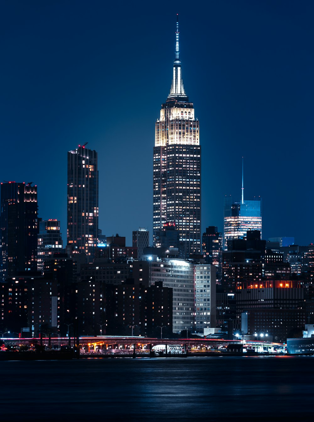 a city skyline at night with a lit up skyscraper