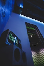 a television sitting on top of a speaker next to a wall