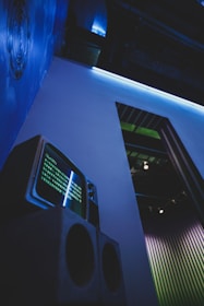 a television sitting on top of a speaker next to a wall