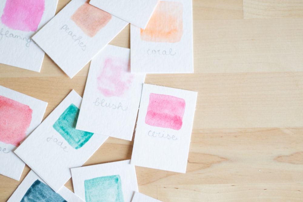 a wooden table topped with lots of different colored cards