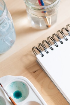 A close-up of unique art supplies like coffee and wine.