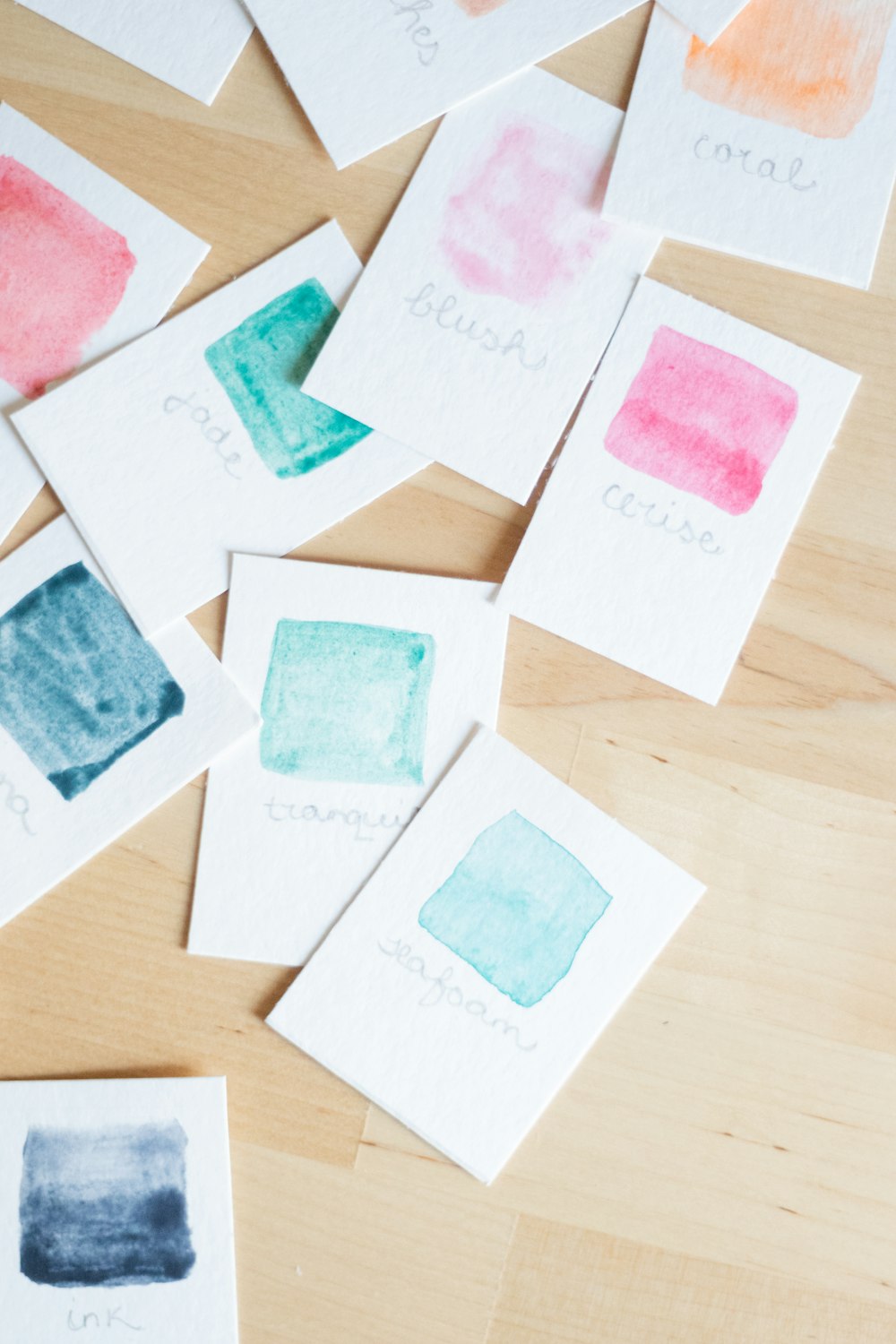 a wooden table topped with lots of watercolor paper