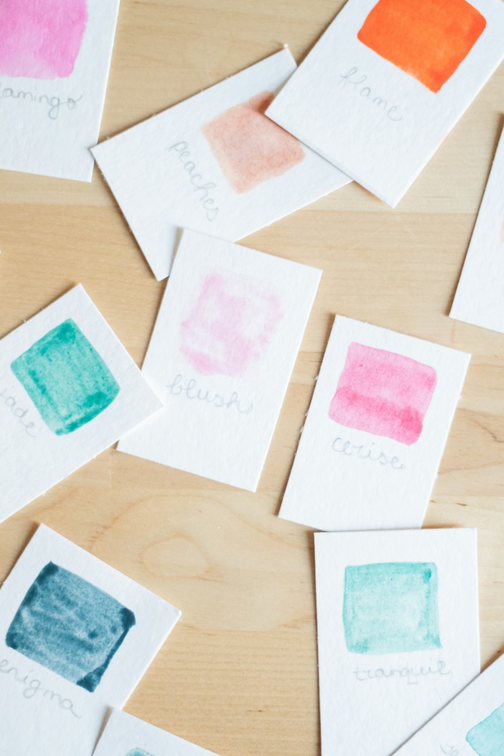 a wooden table topped with lots of different colored cards