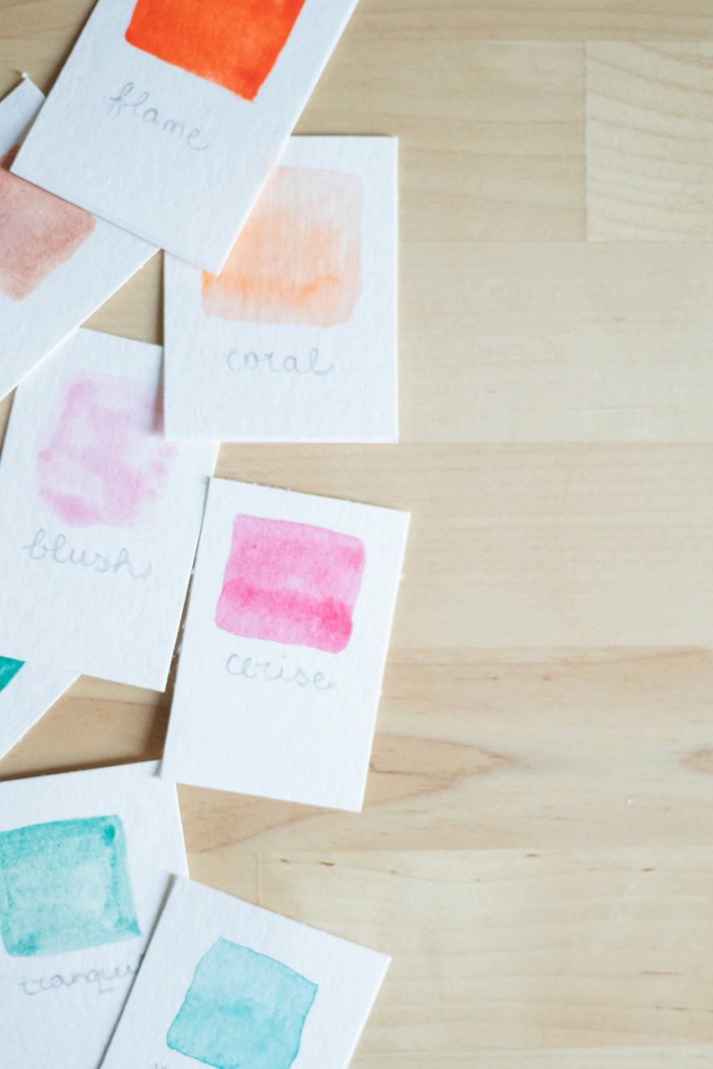 a group of watercolor cards sitting on top of a wooden table