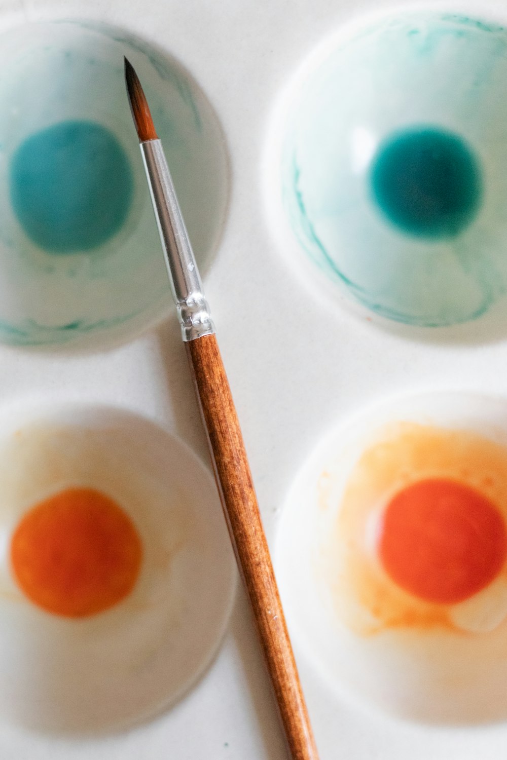 a close up of a paint brush in a bowl