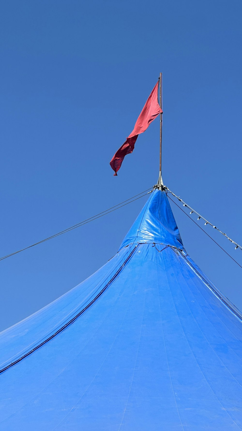 a red flag flying on top of a blue structure