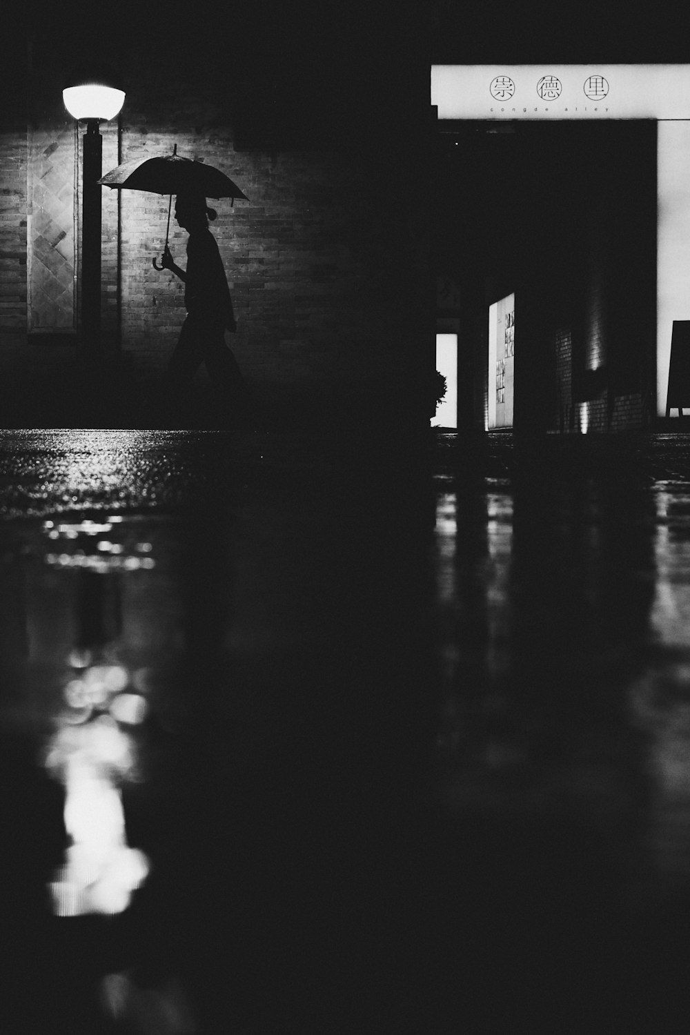 a black and white photo of a person holding an umbrella