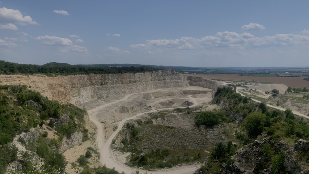 a dirt road going through a large open pit