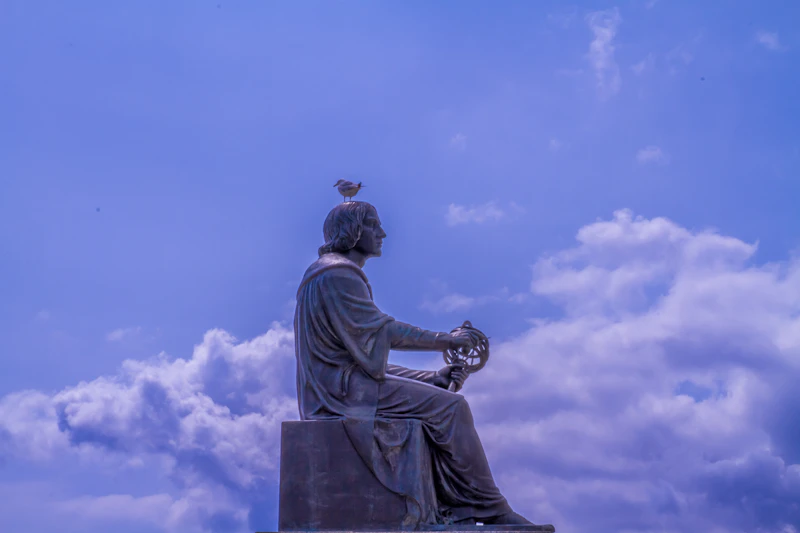 A bird perched atop the Copernicus statue outside the Adler Planetarium in Chicago