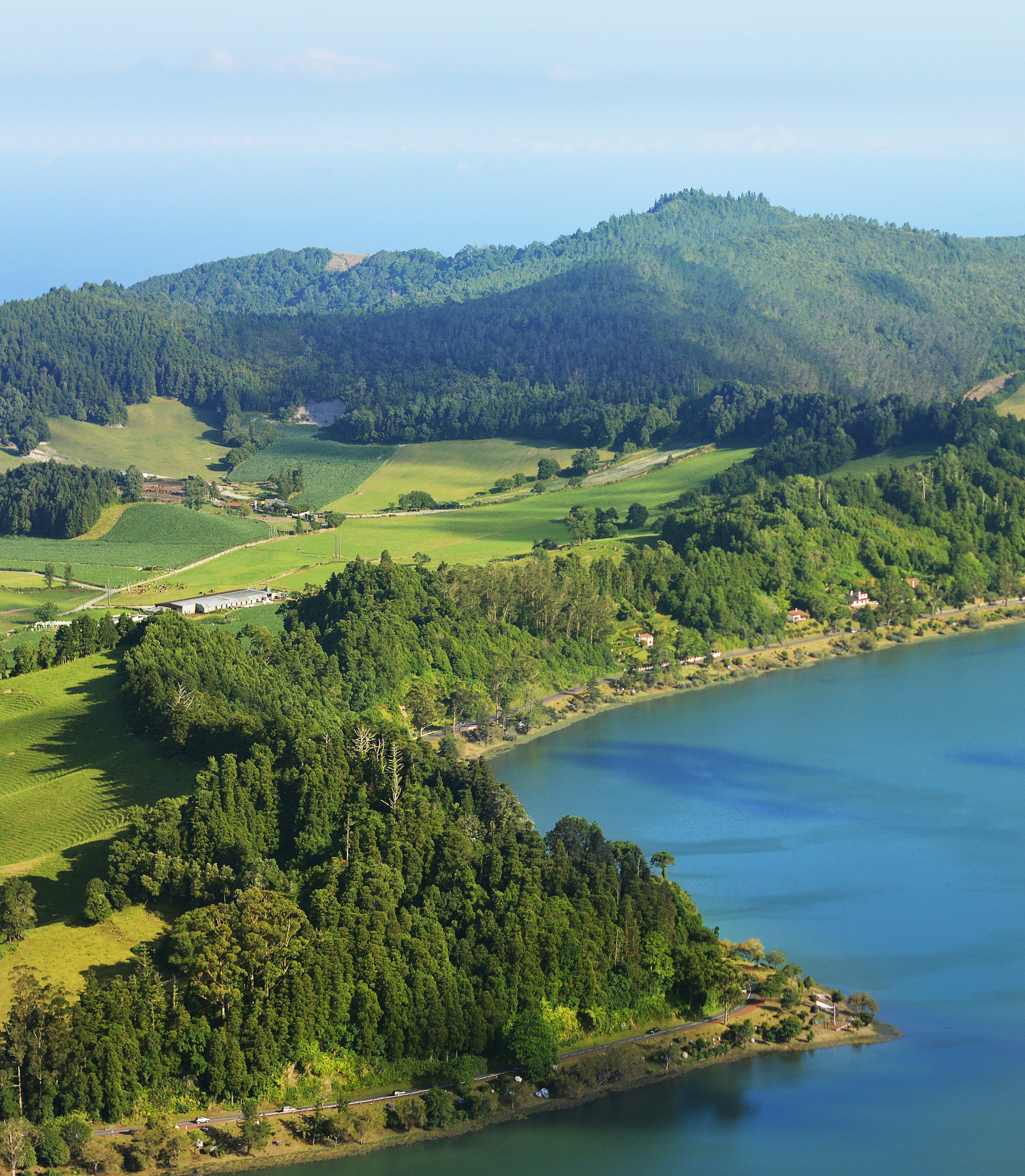 a large body of water surrounded by lush green hills