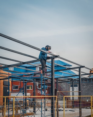 Photo of a construction team collaborating on-site with welding sparks in the background.