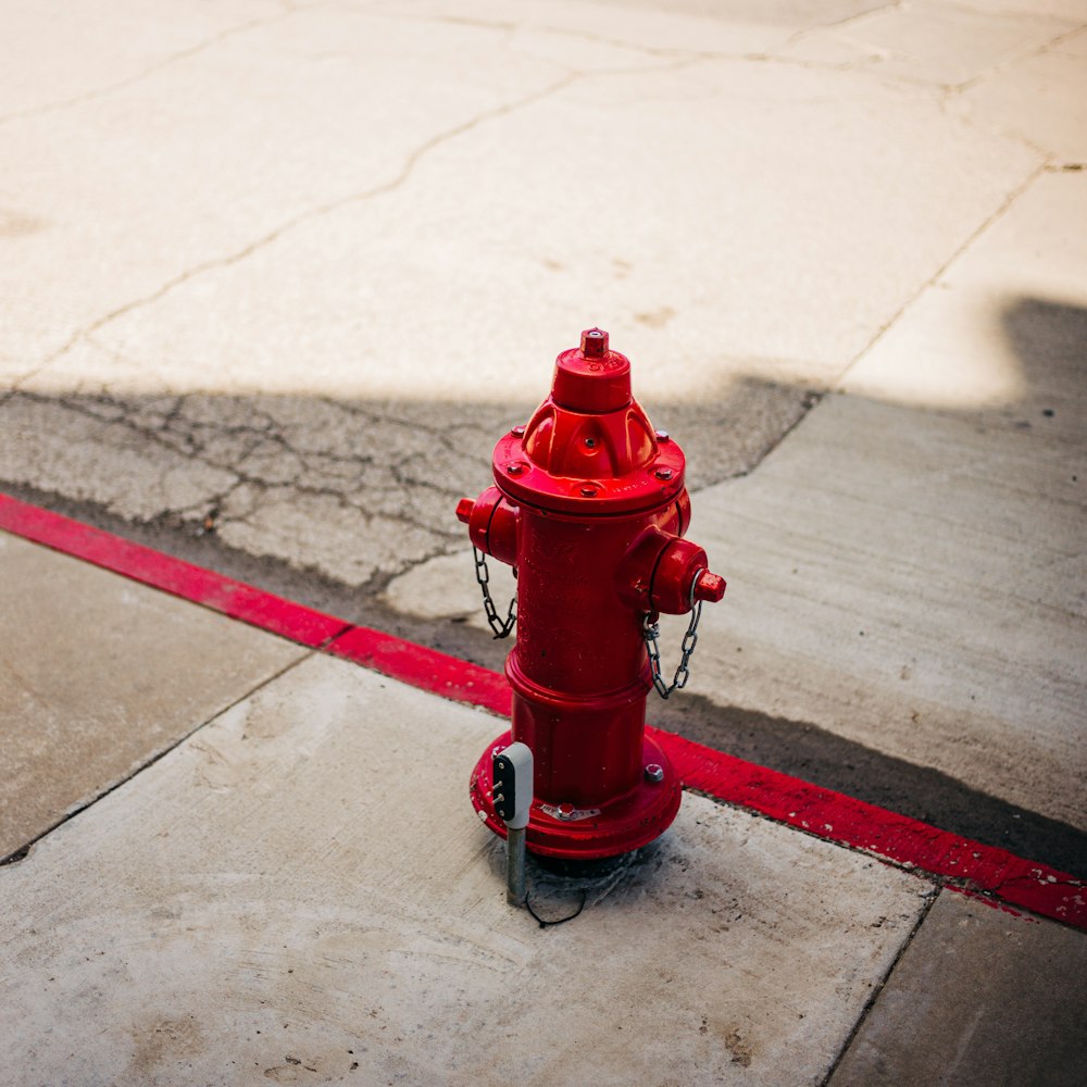 a red fire hydrant sitting on the side of a road