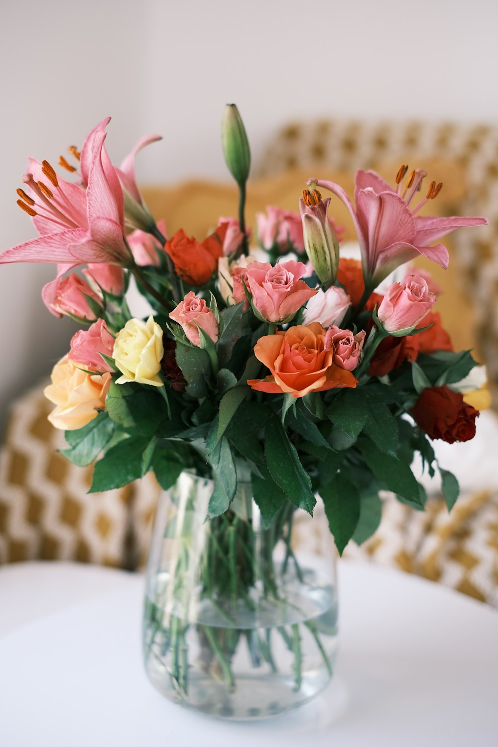 a vase filled with lots of flowers on top of a table