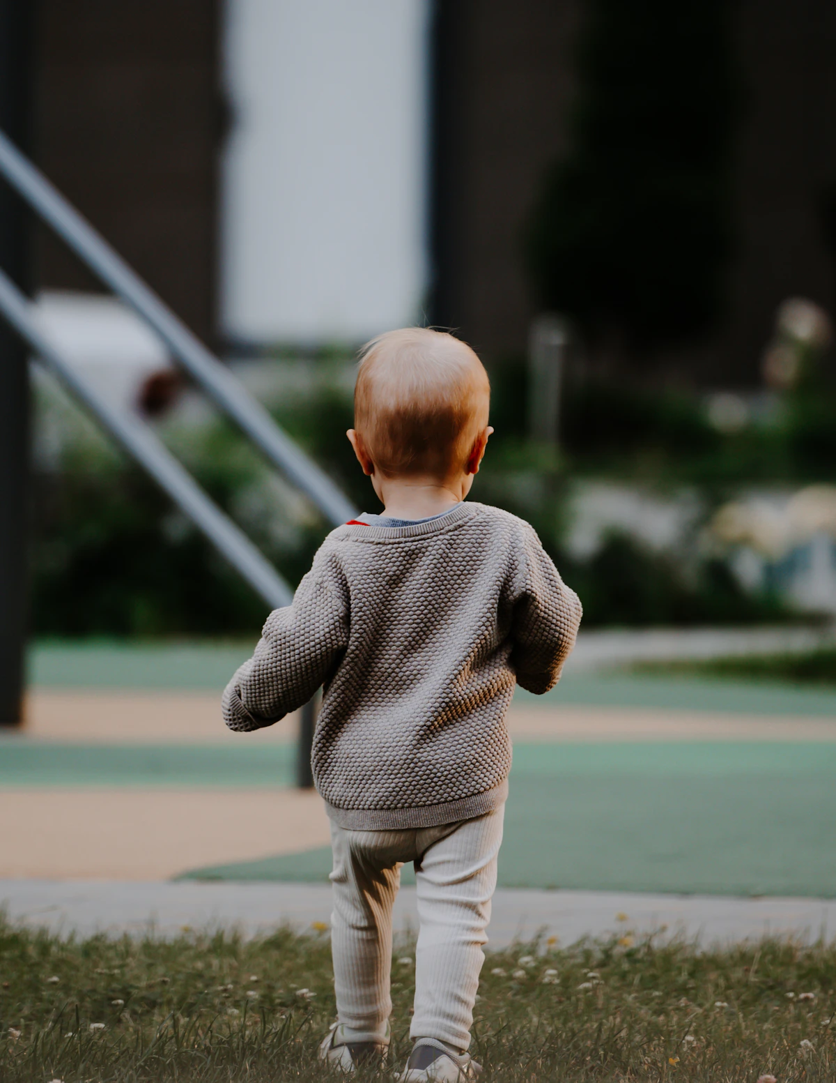A walking 1-year-old exploring outdoors on his own two feet