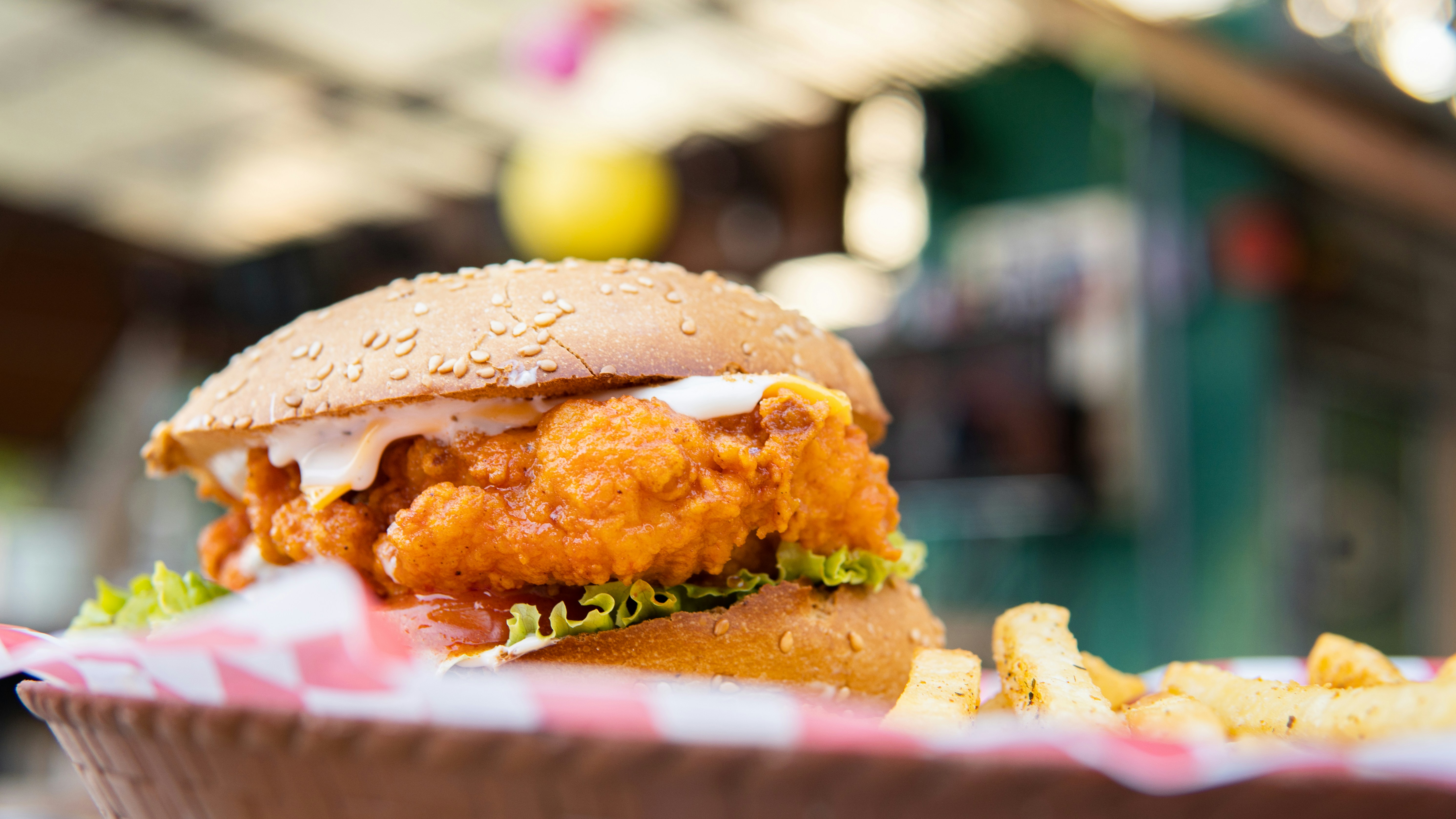 ein Hähnchensandwich mit Salat und Tomate auf einem Brötchen