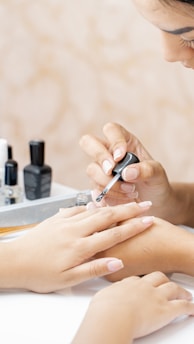 a woman is doing a manicure on a woman's hand