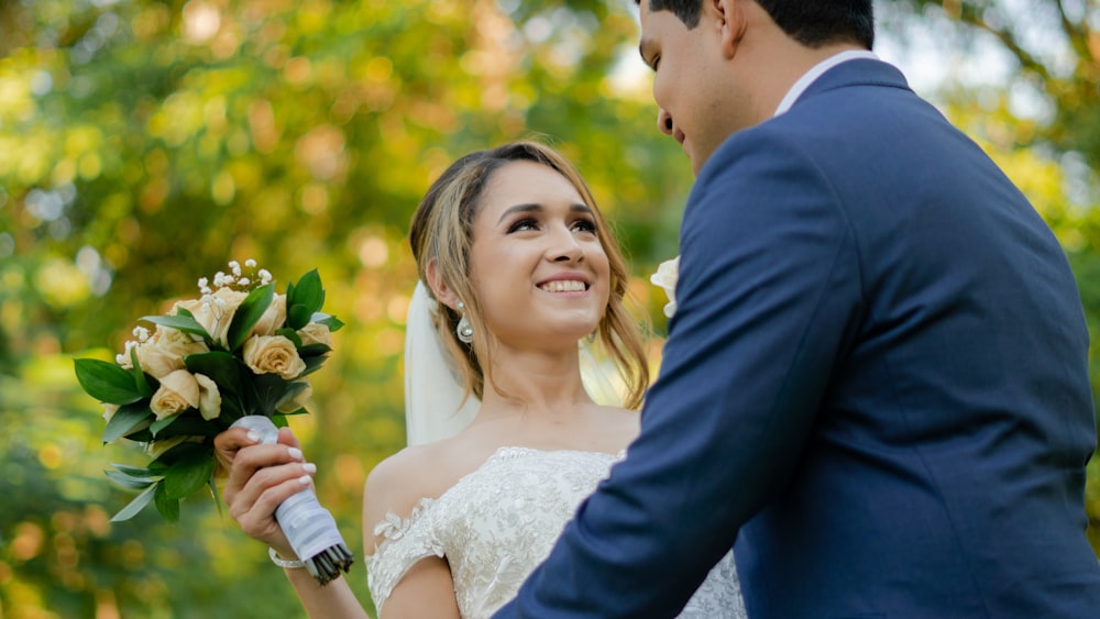 a bride and groom holding a bouquet of flowers
