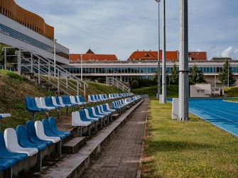 a row of blue and white chairs sitting on top of a tennis court