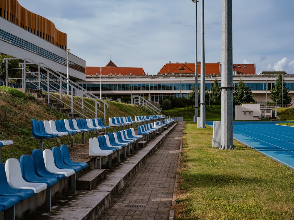 a row of blue and white chairs sitting on top of a tennis court