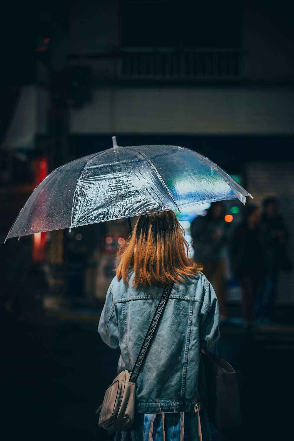 a woman walking down a street holding an umbrella