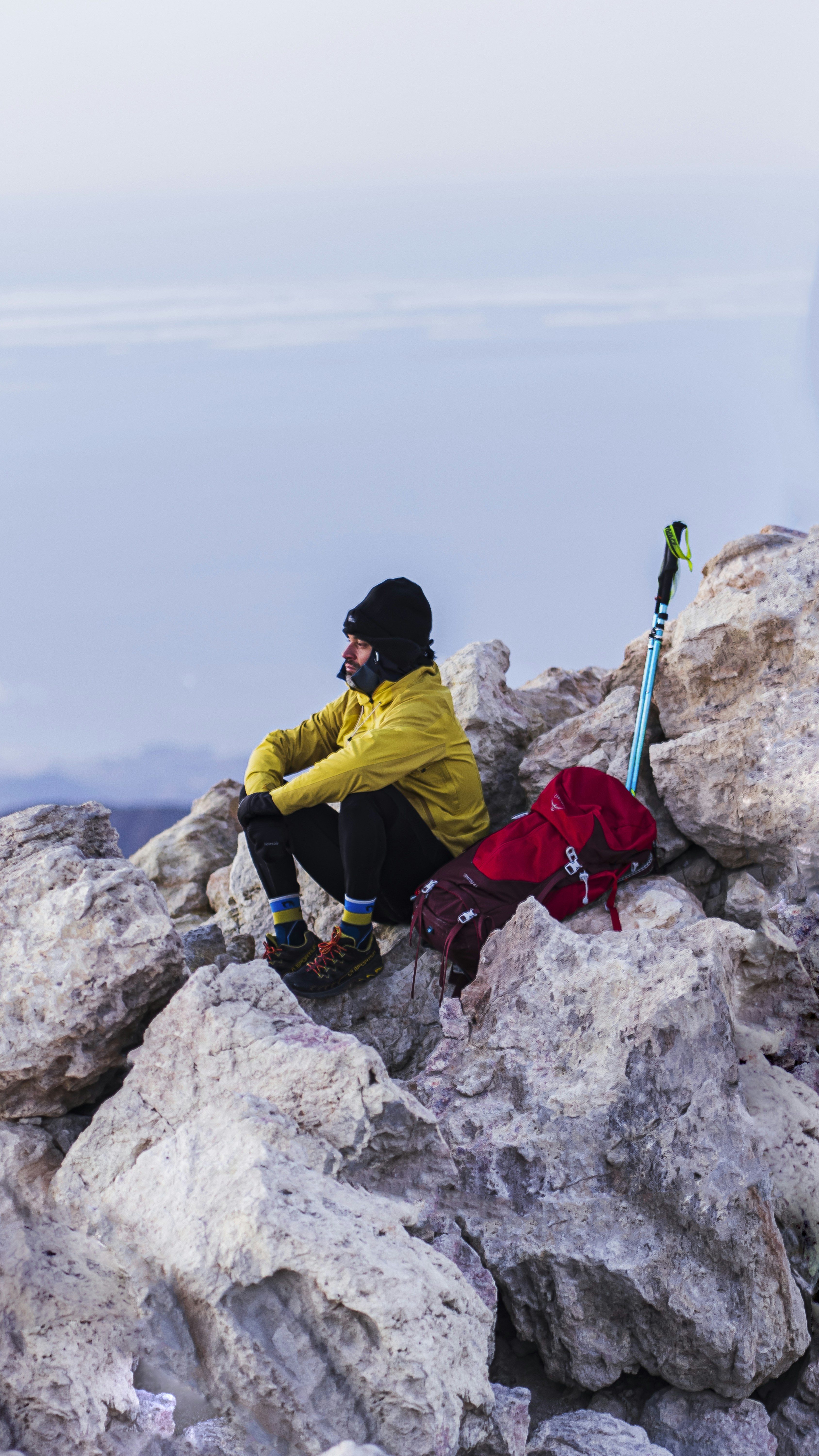 a man sitting on top of a large pile of rocks
