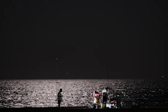 A group of club members proudly holding their fishing rods by the lake at sunrise.