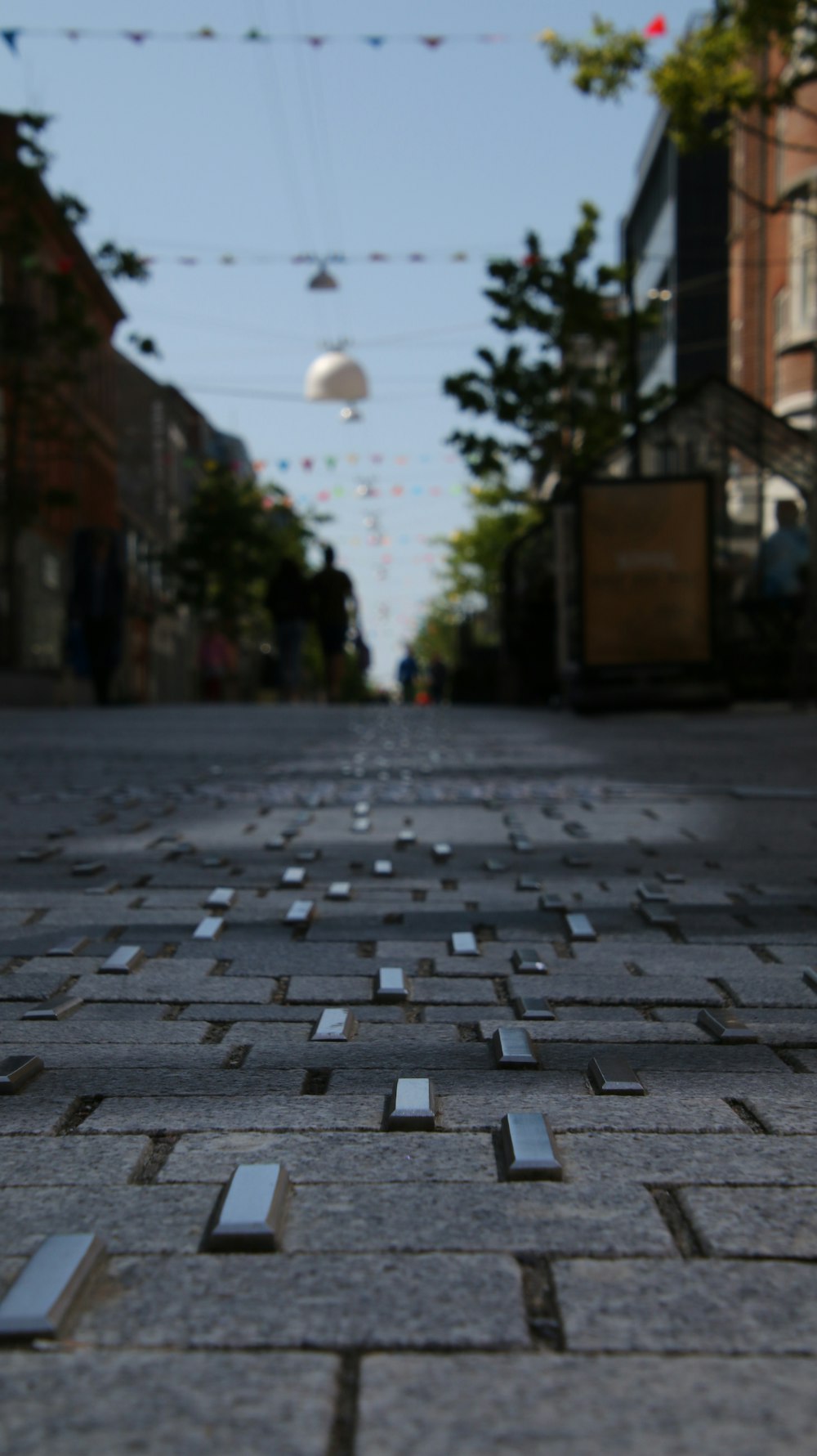 an empty street with a string of lights in the background