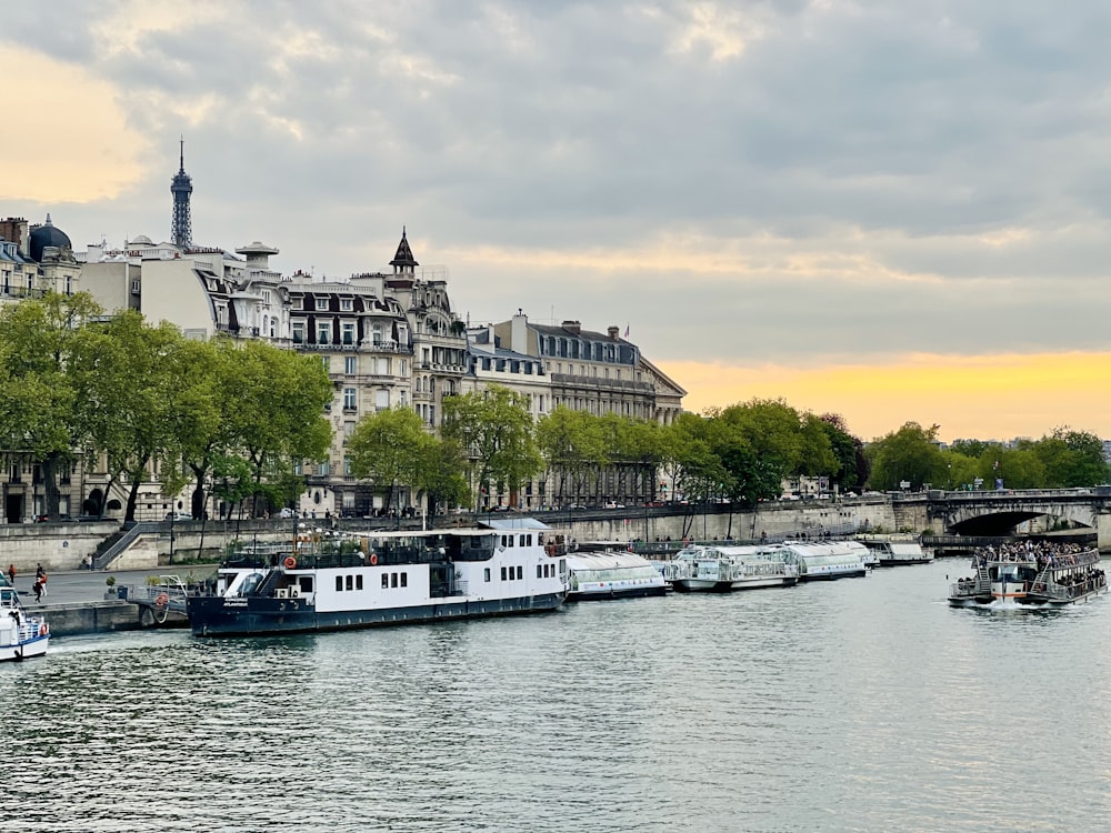 a river filled with lots of boats next to tall buildings