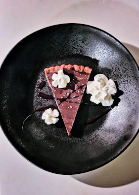 An elegant dessert plate featuring a slice of chocolate cake with a drizzle of caramel.