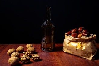 a bag full of nuts next to a bottle of wine
